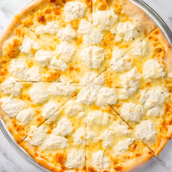 A whole white pizza from Dragos Pizza, topped with mozzarella and ricotta cheese, sliced into eight pieces.